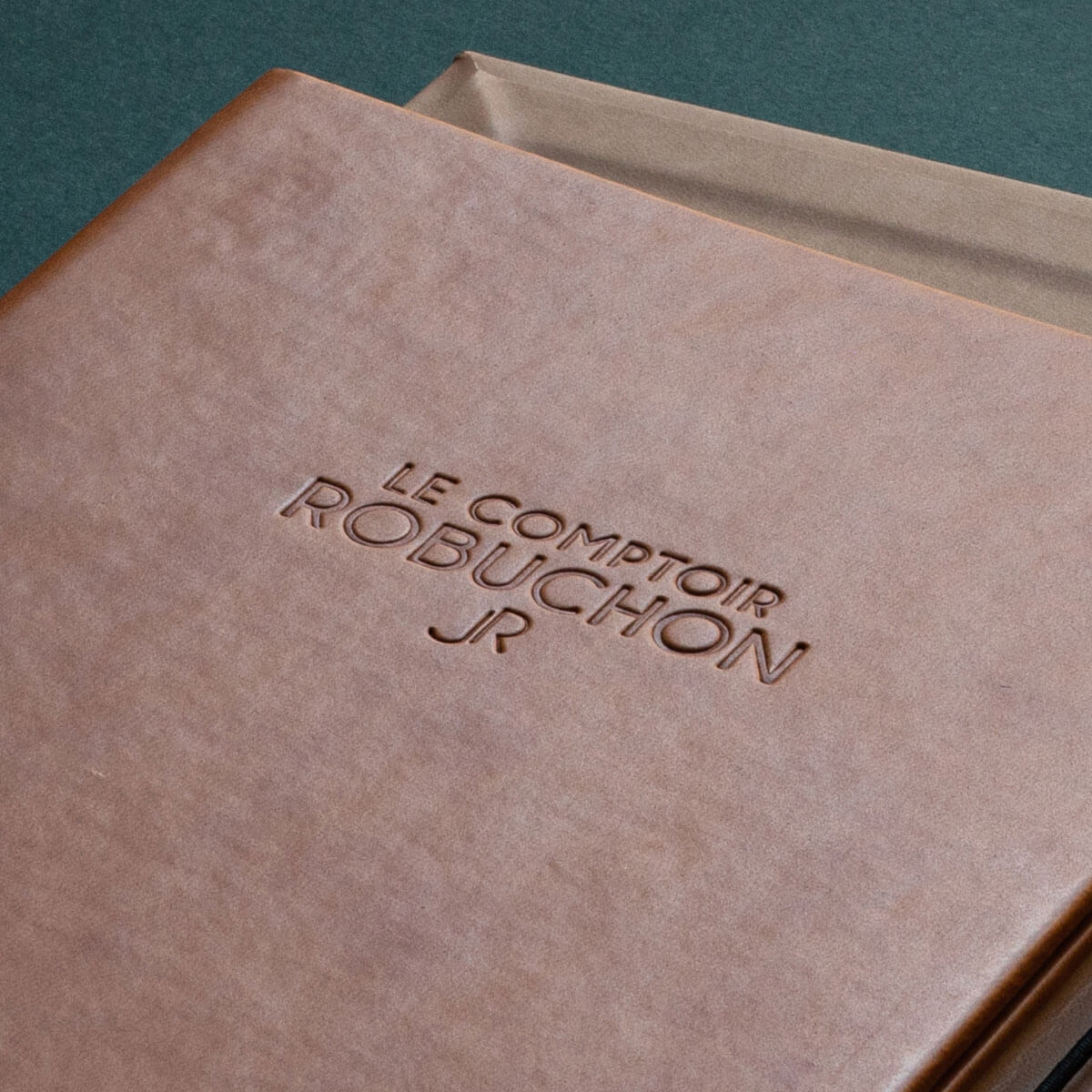 brown debossed leather logo printed on a menu folder in london