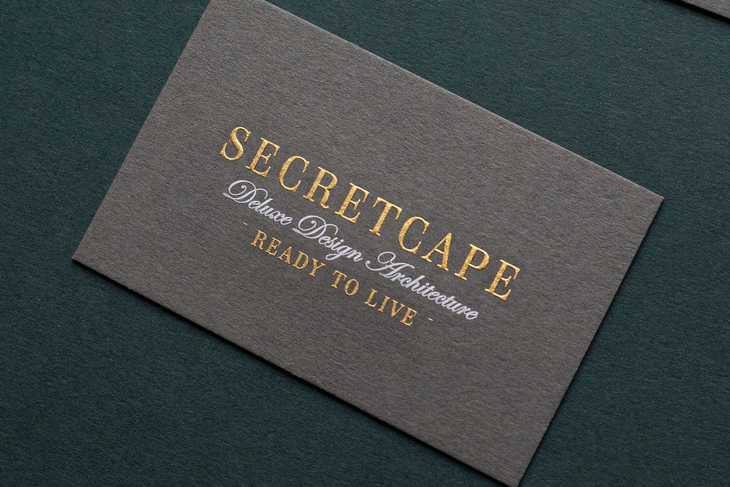 luxury stationery die stamped in gold with white text on grey card