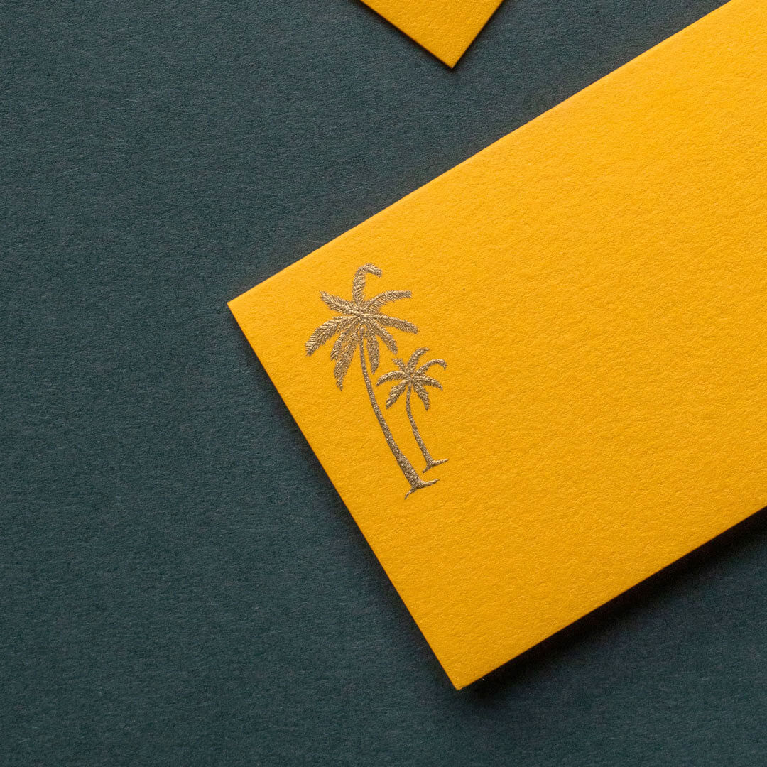 gold engraved palm tree design printed on luxury yellow business card