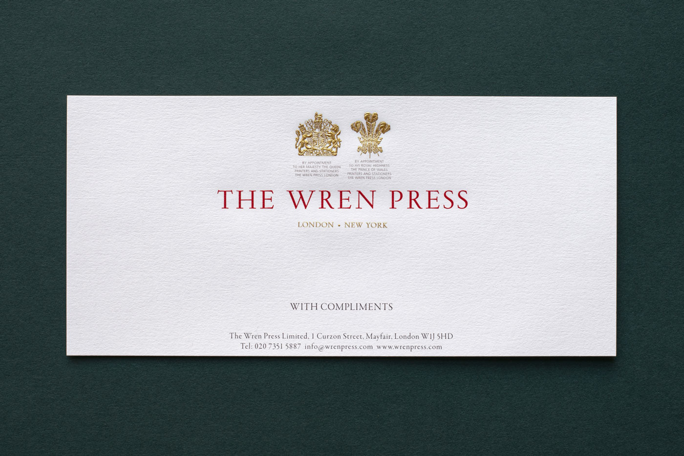 a white compliment slip with traditional gold die stamped logo